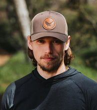 Load image into Gallery viewer, Man wearing a cap with a logo outdoors
